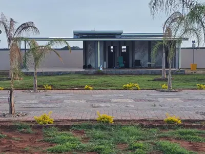 a house with palm trees in front of it at KGADITSE ROAD LODGE in Moletlane