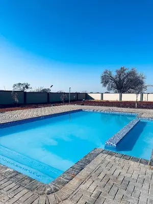 a large swimming pool with blue water at KGADITSE ROAD LODGE in Moletlane