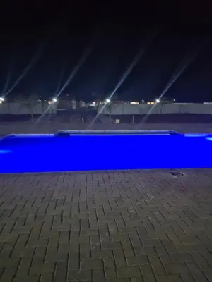a blue empty pool at night with lights at KGADITSE ROAD LODGE in Moletlane