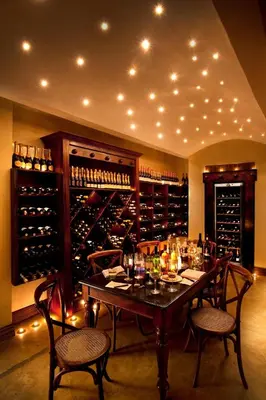 a dining room with a table with chairs and wine bottles at Lion Sands - Tinga Lodge in Skukuza