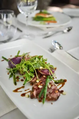 a white plate of food on a table at Lion Sands - Tinga Lodge in Skukuza
