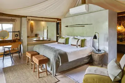 a bedroom with a large bed and a desk at Marataba Safari Lodge in Hartbeestfontein