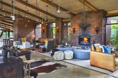 a living room with a brick wall and a fireplace at Marataba Safari Lodge in Hartbeestfontein