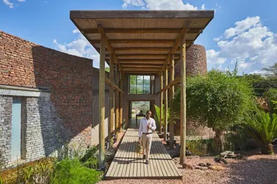 a man standing on a wooden walkway in front of a building at Marataba Safari Lodge in Hartbeestfontein