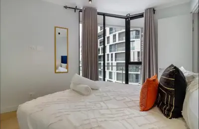 a bedroom with a large bed and a large window at Ellipse Cassini @ Waterfall (Fili) in Midrand