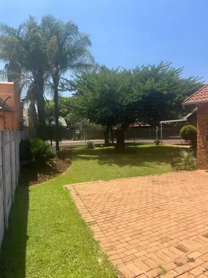 a yard with a brick path and trees and a fence at Centurion Family House in Centurion