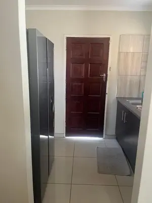 a kitchen with a brown door and a sink at Centurion Family House in Centurion