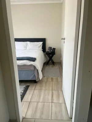 a bedroom with a bed and a wooden floor at Centurion Family House in Centurion