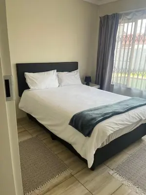 a bedroom with a large bed with white sheets at Centurion Family House in Centurion