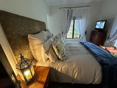 a bedroom with a bed with a lamp and a window at Giverny in Dullstroom