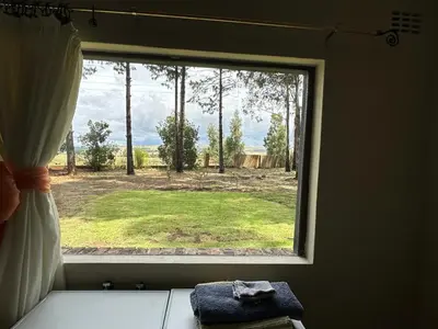 a window with a view of a field of grass at Giverny in Dullstroom