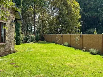 a backyard with a fence and a grass yard at Giverny in Dullstroom