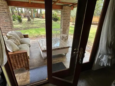 a glass door to a patio with a couch and a table at Giverny in Dullstroom
