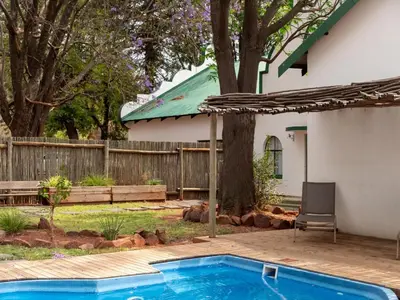 a swimming pool in a yard next to a house at Zebra Nature Reserve in Cullinan