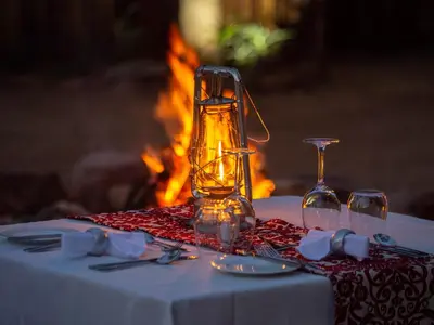 a table with two glasses and a bottle on it at Nkomazi Game Reserve by NEWMARK in Badplaas