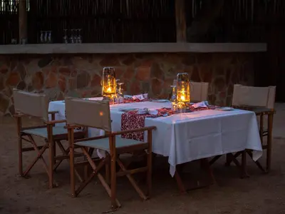 a table with a white table cloth and candles on it at Nkomazi Game Reserve by NEWMARK in Badplaas