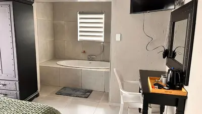a bathroom with a bath tub and a sink at Nandoni Junction GuestVilla, Nandoni Thohoyandou in Vendaland