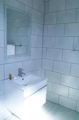 a white bathroom with a sink and a mirror at Nandoni Junction GuestVilla, Nandoni Thohoyandou in Vendaland
