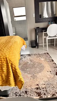 a bathroom with a yellow blanket on a rug at Nandoni Junction GuestVilla, Nandoni Thohoyandou in Vendaland