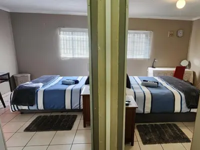 two beds in a room with mats on the floor at Middelbult Guesthouse by Heybert in Secunda