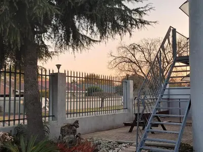 a staircase leading to a gate with a tree at Middelbult Guesthouse by Heybert in Secunda