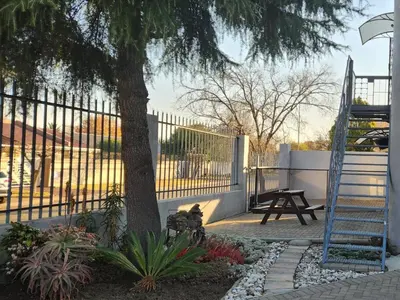 a fence with a tree and a picnic table at Middelbult Guesthouse by Heybert in Secunda