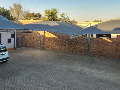 a large blue umbrella in front of a brick wall at Middelbult Guesthouse by Heybert in Secunda