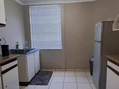 a kitchen with a refrigerator and a sink and a window at Middelbult Guesthouse by Heybert in Secunda