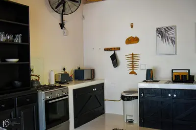 a kitchen with black cabinets and a stove at Luxury GuesthouseCo RomanticaHouse in Marloth Park