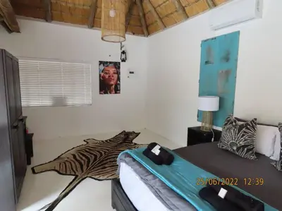 a bedroom with a zebra decoration on the wall at Luxury GuesthouseCo RomanticaHouse in Marloth Park
