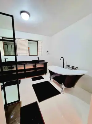 a large bathroom with a tub and a sink at Luxury GuesthouseCo FarmHouse in Marloth Park