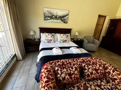 a hotel room with a bed with towels on it at Hornbill Helipad 2 in Centurion