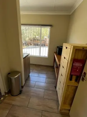 a kitchen with a large window and a tile floor at Hornbill Helipad 2 in Centurion