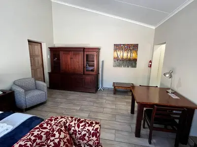 a living room with a desk and a table at Hornbill Helipad 2 in Centurion