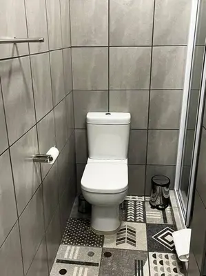 a bathroom with a white toilet in a stall at Hornbill Helipad 2 in Centurion