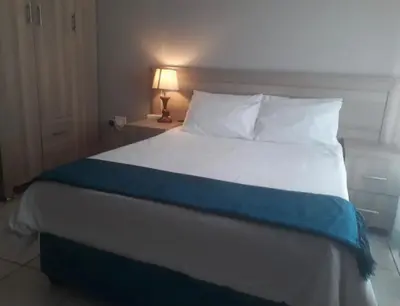a bedroom with a bed with a blue and white blanket at Rethabile Guesthouse in Bochum