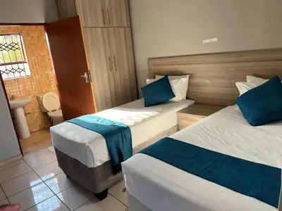 a hotel room with two beds and a bathroom at Rethabile Guesthouse in Bochum