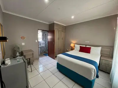 a hotel room with a bed and a bathroom at Rethabile Guesthouse in Bochum