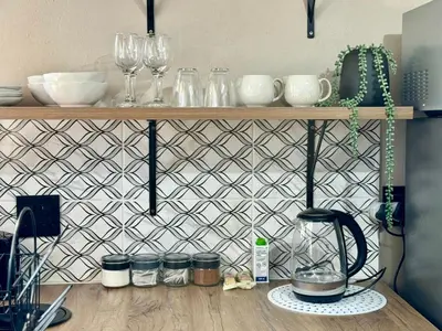 a kitchen counter with a shelf with wine glasses at Sugar Plum Rest in Polokwane