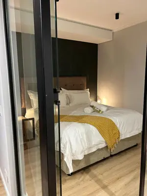 a bedroom with a bed with a black wall at Thando's Luxury Stays at Ellipse, Waterfall in Midrand