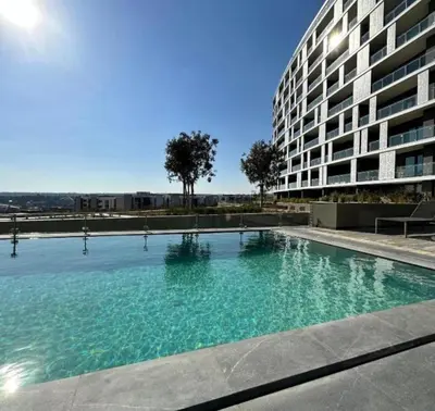 a large swimming pool in front of a building at Thando's Luxury Stays at Ellipse, Waterfall in Midrand
