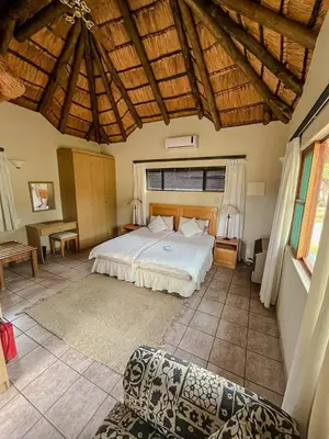a bedroom with a bed and a couch in a room at ILANGA Lodge & Game Reserve in Kwarriekraal