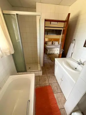 a bathroom with a bath tub and a sink at ILANGA Lodge & Game Reserve in Kwarriekraal