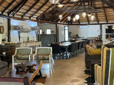 a living room with a table and a dining room at Sabella Bushveld Lodge in Marble Hall