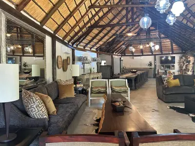 a large living room with couches and a table at Sabella Bushveld Lodge in Marble Hall