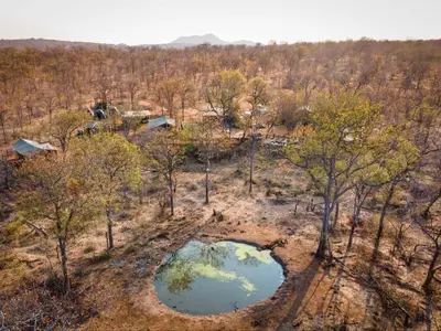 an aerial view of a forest with two ponds at Khanya Safari Lodge in Phalaborwa