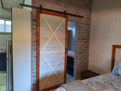 a sliding barn door in a bedroom with a bed at 1@Kruger Unit 3 in Mokopane