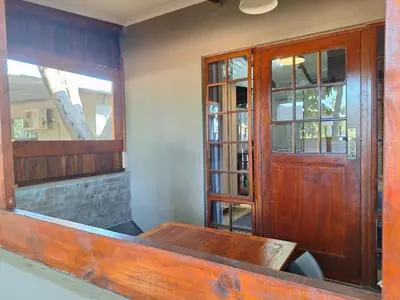 a room with a table and a wooden door at 1@Kruger Unit 3 in Mokopane