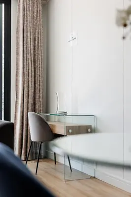 a glass table and a chair in a living room at Elipse Waterfall-2802 in Midrand