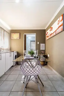 a kitchen with a table and a chair in a room at Cheerful Cottage in Johannesburg